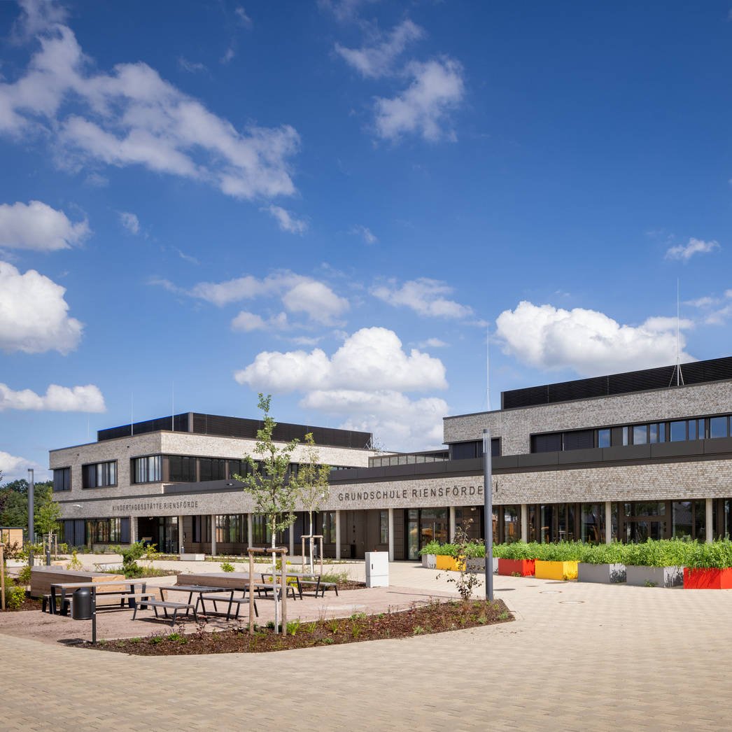 Außenansicht des Bildungscampus Riensförde mit einem großzügigen Pausenhof.